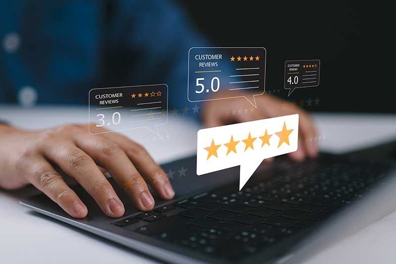 A person is typing on a laptop computer with a speech bubble that says five stars.