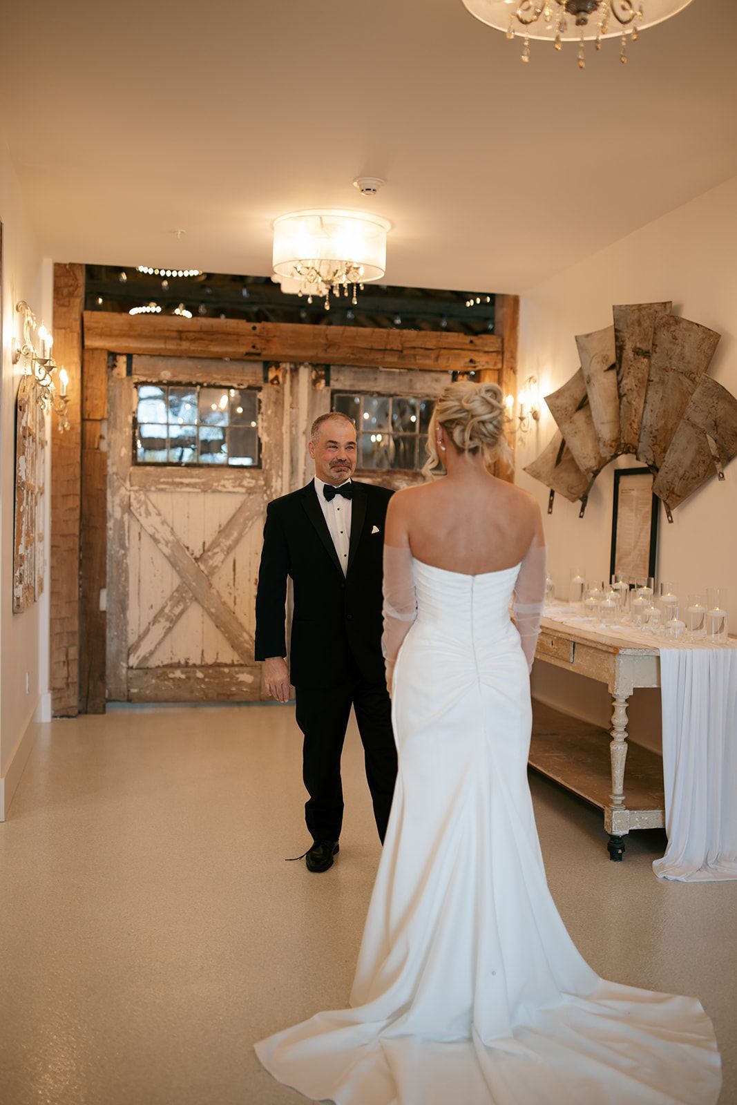 Bride in white gown faces groom in tuxedo at wedding venue entrance