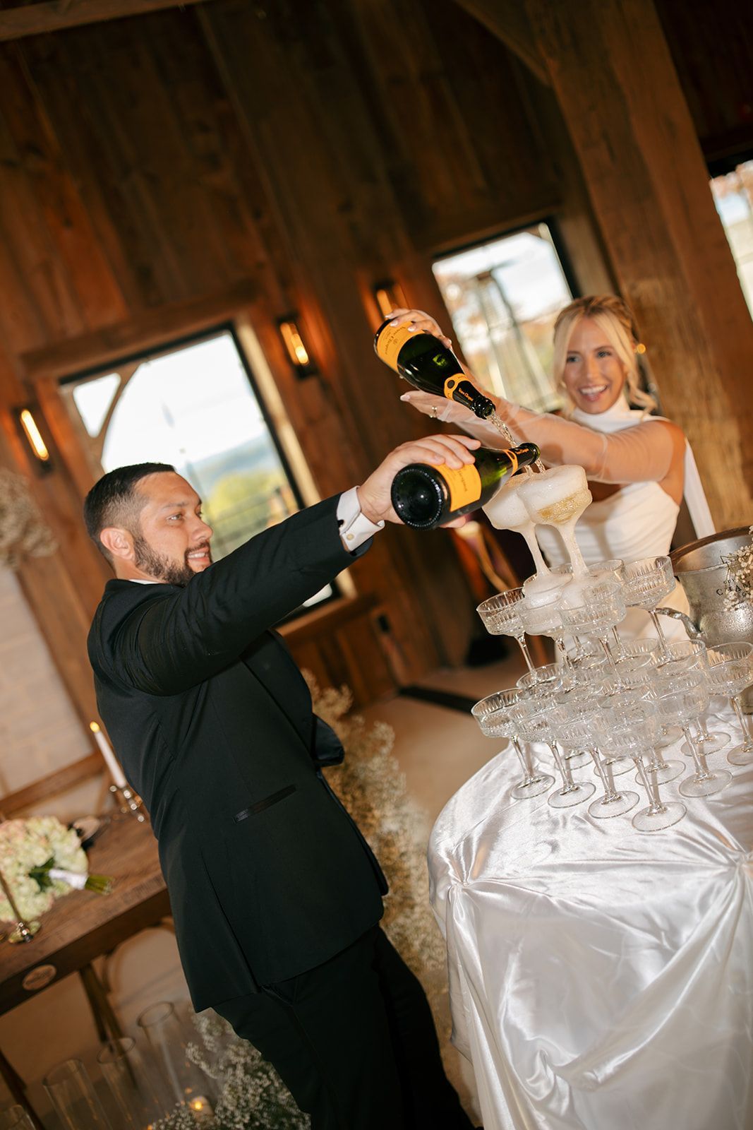 Bride and groom cutting a champagne tower at a wedding reception