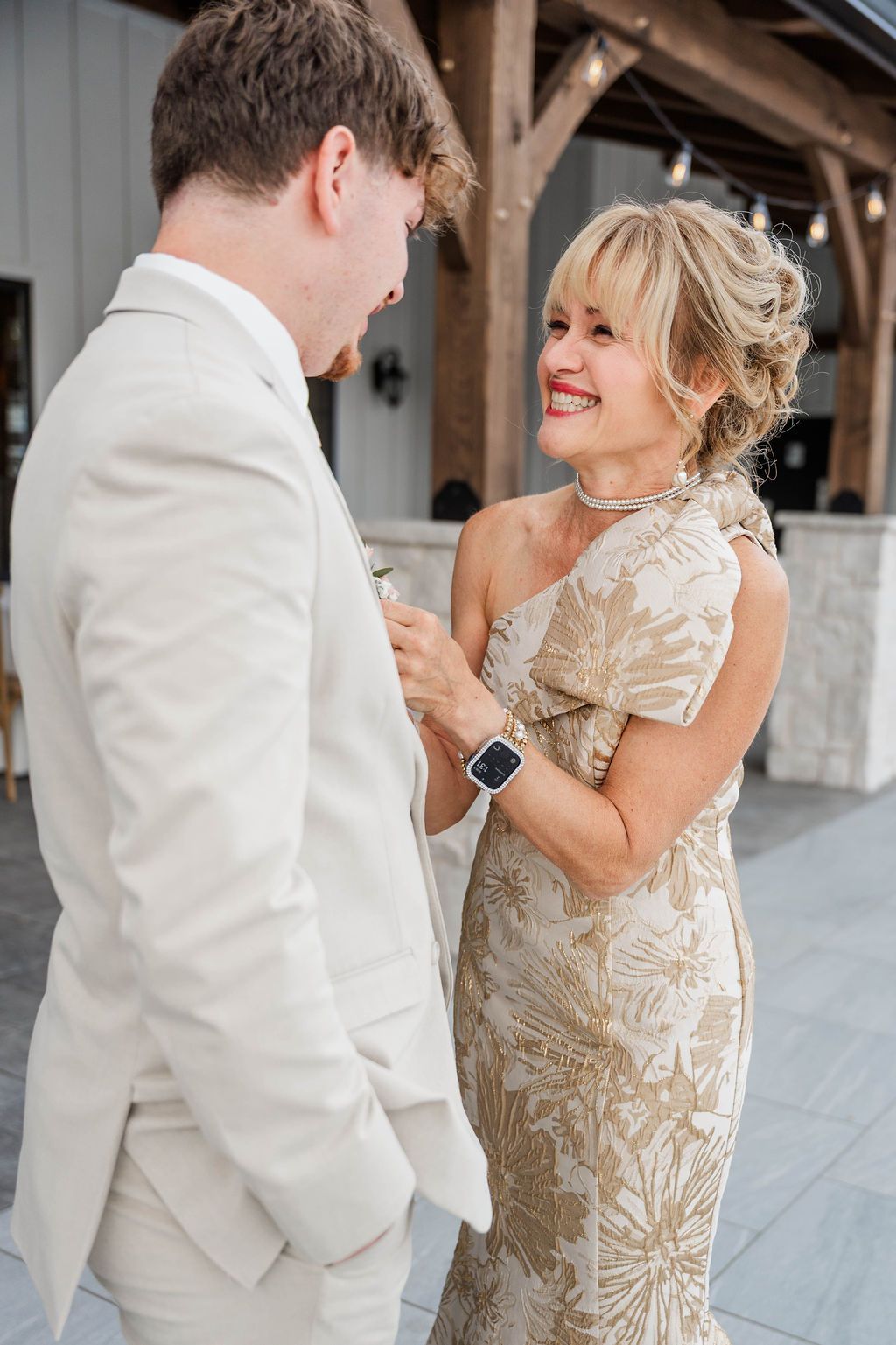 Two people in formal attire smiling and talking at a wedding venue