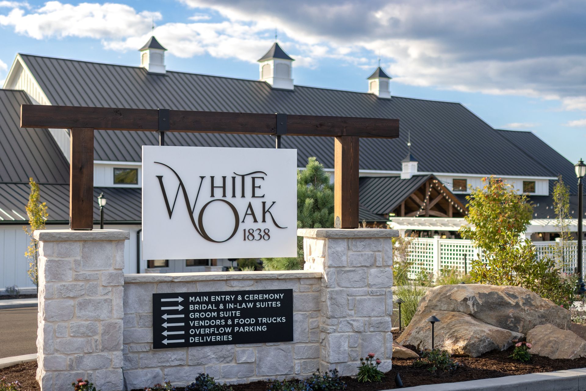White Oak 1878 entrance sign in front of a barn-style building under a blue sky