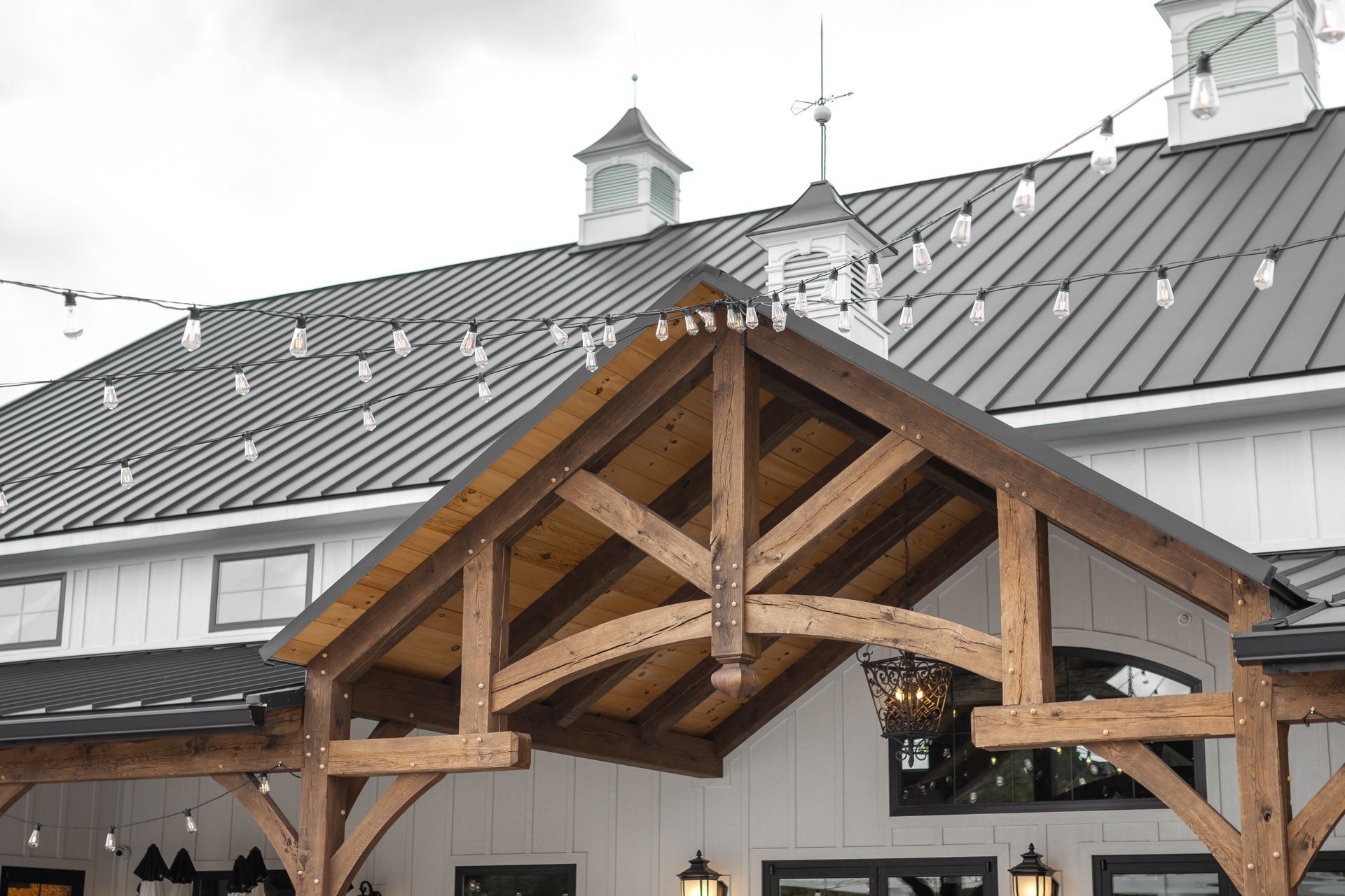 Wooden porch entrance with exposed beams on a snowy building roof