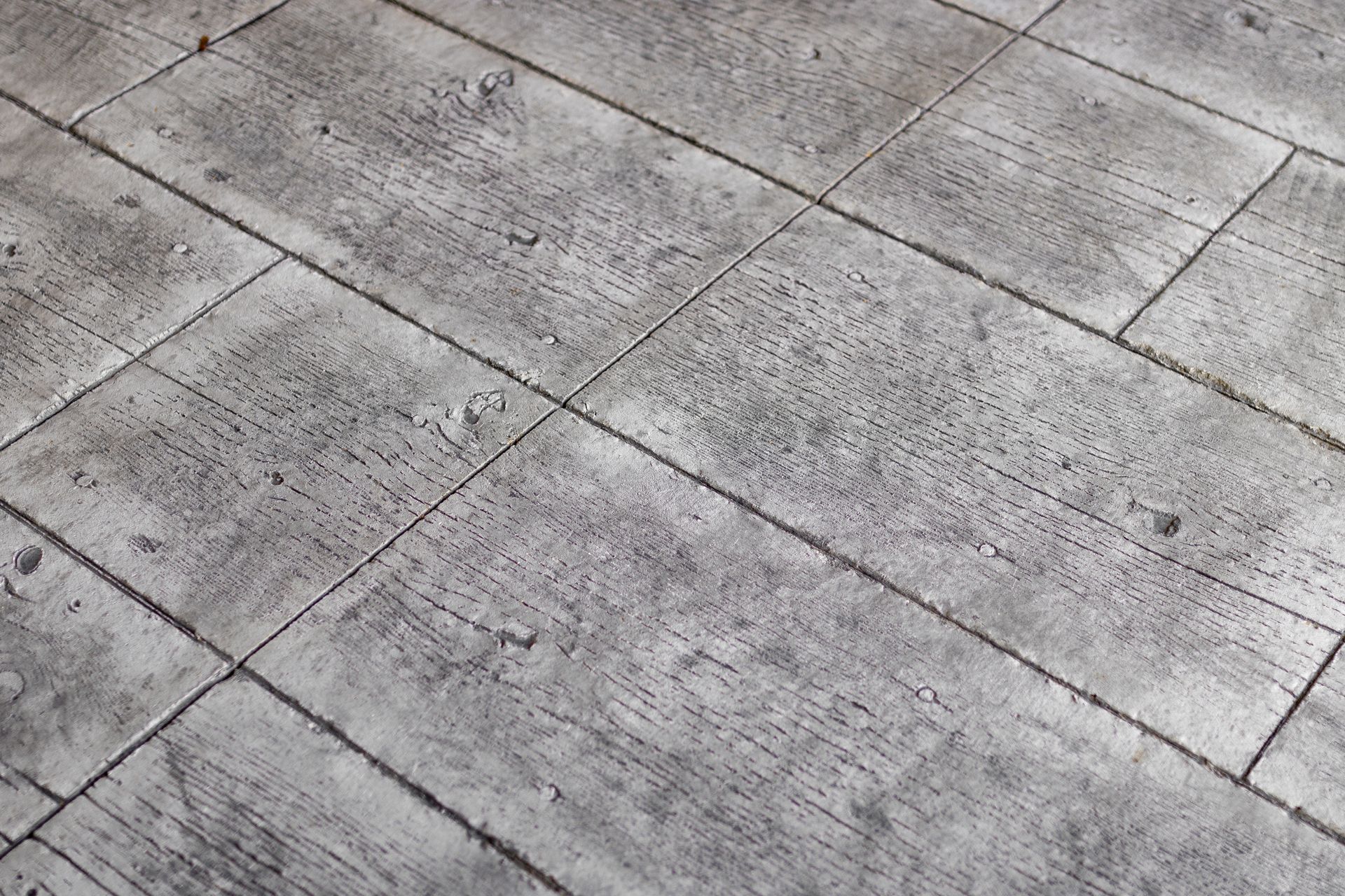 Gray stone pavement with diagonal tile lines and a rough textured surface