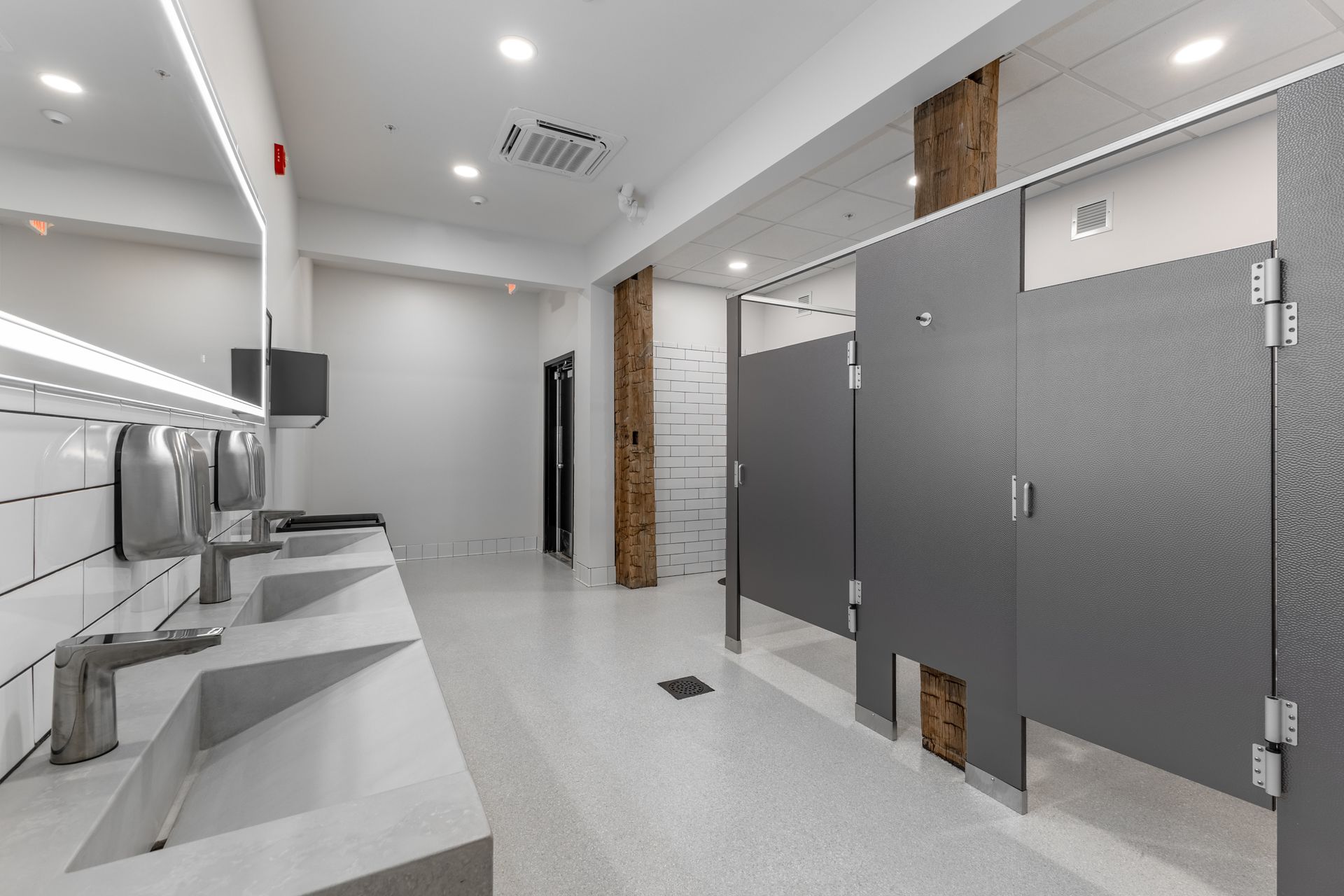 White Oak 1838's restroom interior with gray stalls, white sinks, and bright overhead lighting