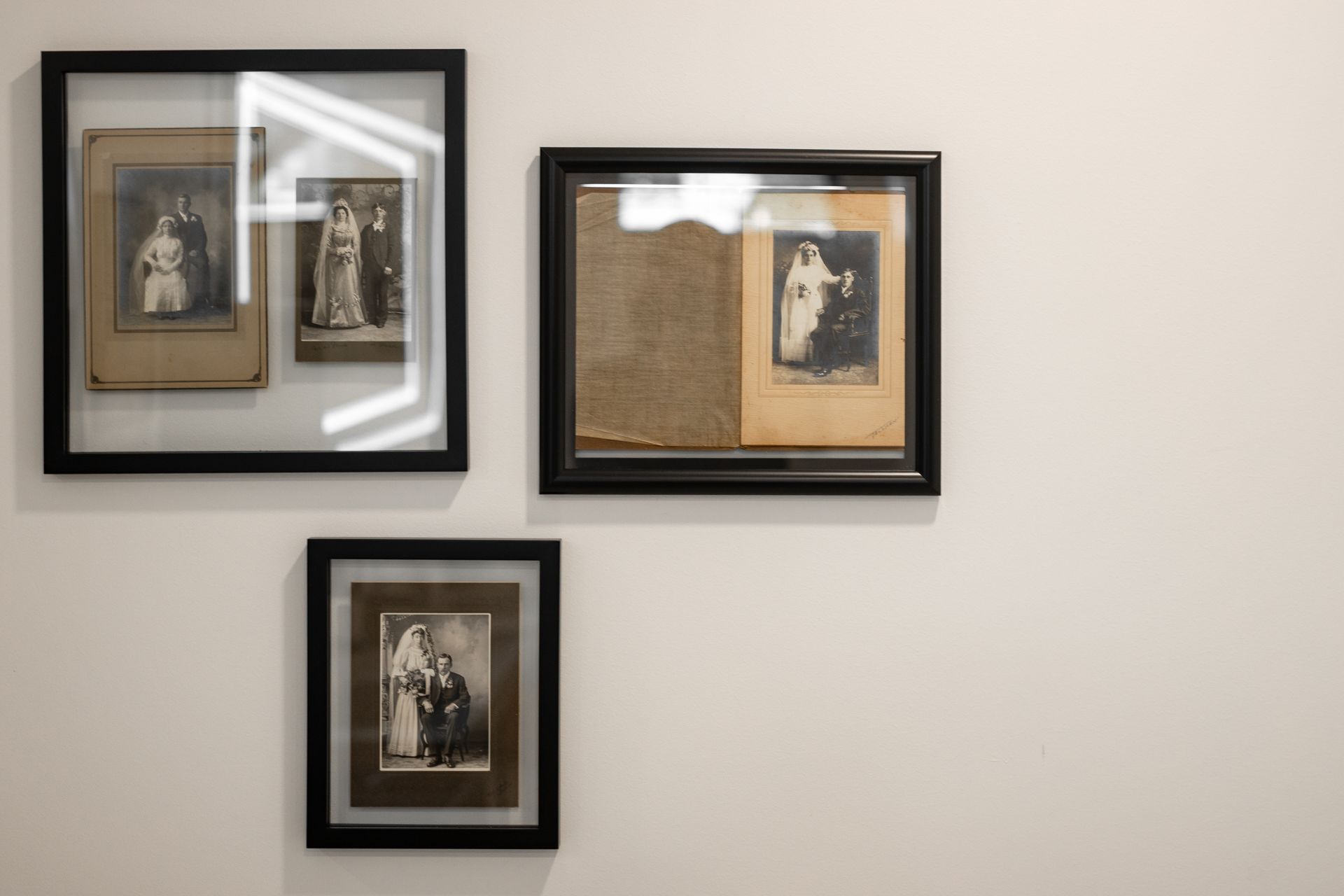 Three framed vintage prints on a light-colored wall, two above and one below.