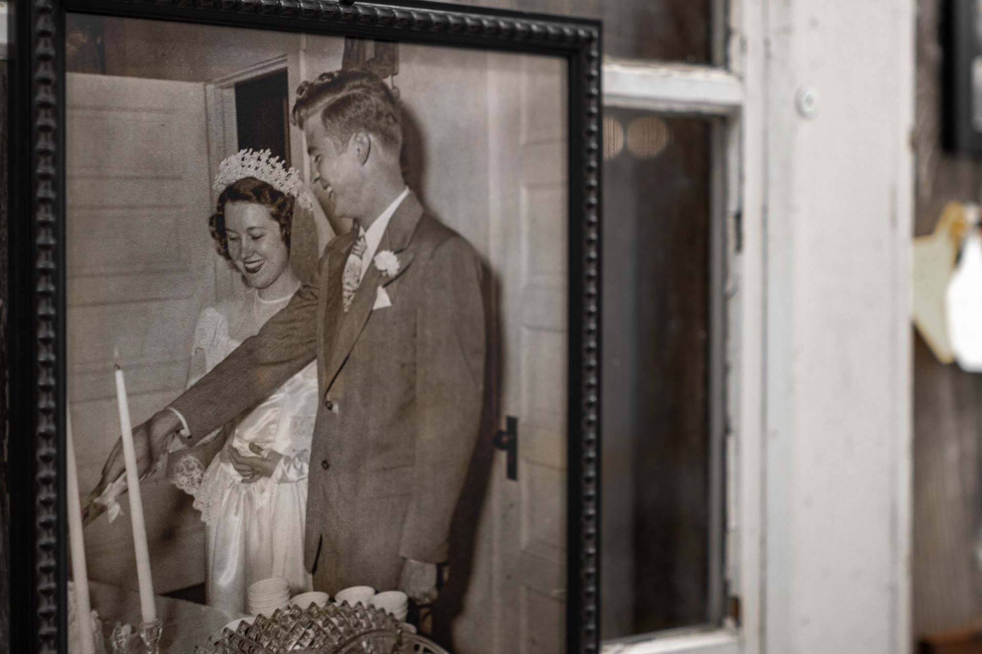 Framed black-and-white wedding photo on a windowsill, showing a bride and groom