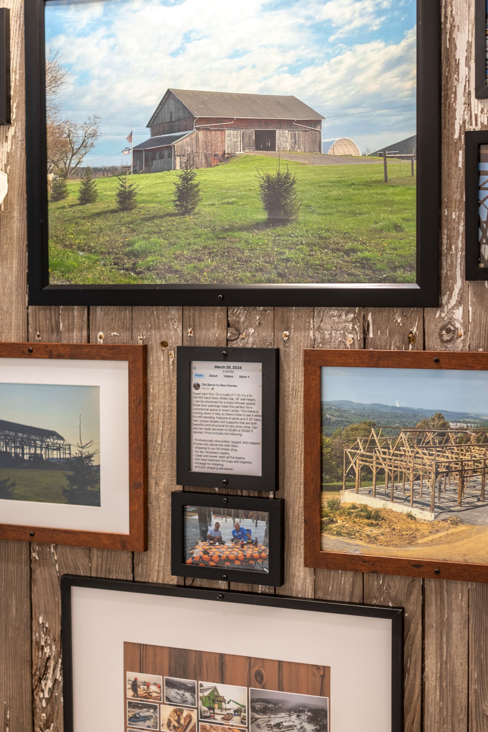 Framed landscape paintings on a rustic wood wall, including a barn scene and coastal views