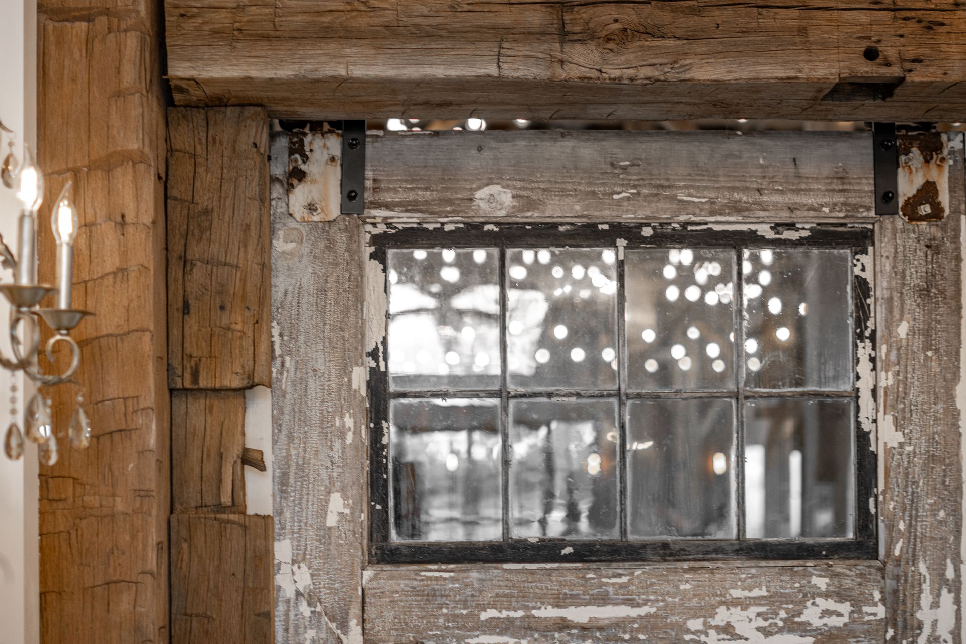 Weathered wooden wall with a cracked, dirty window and soft light filtering through broken panes