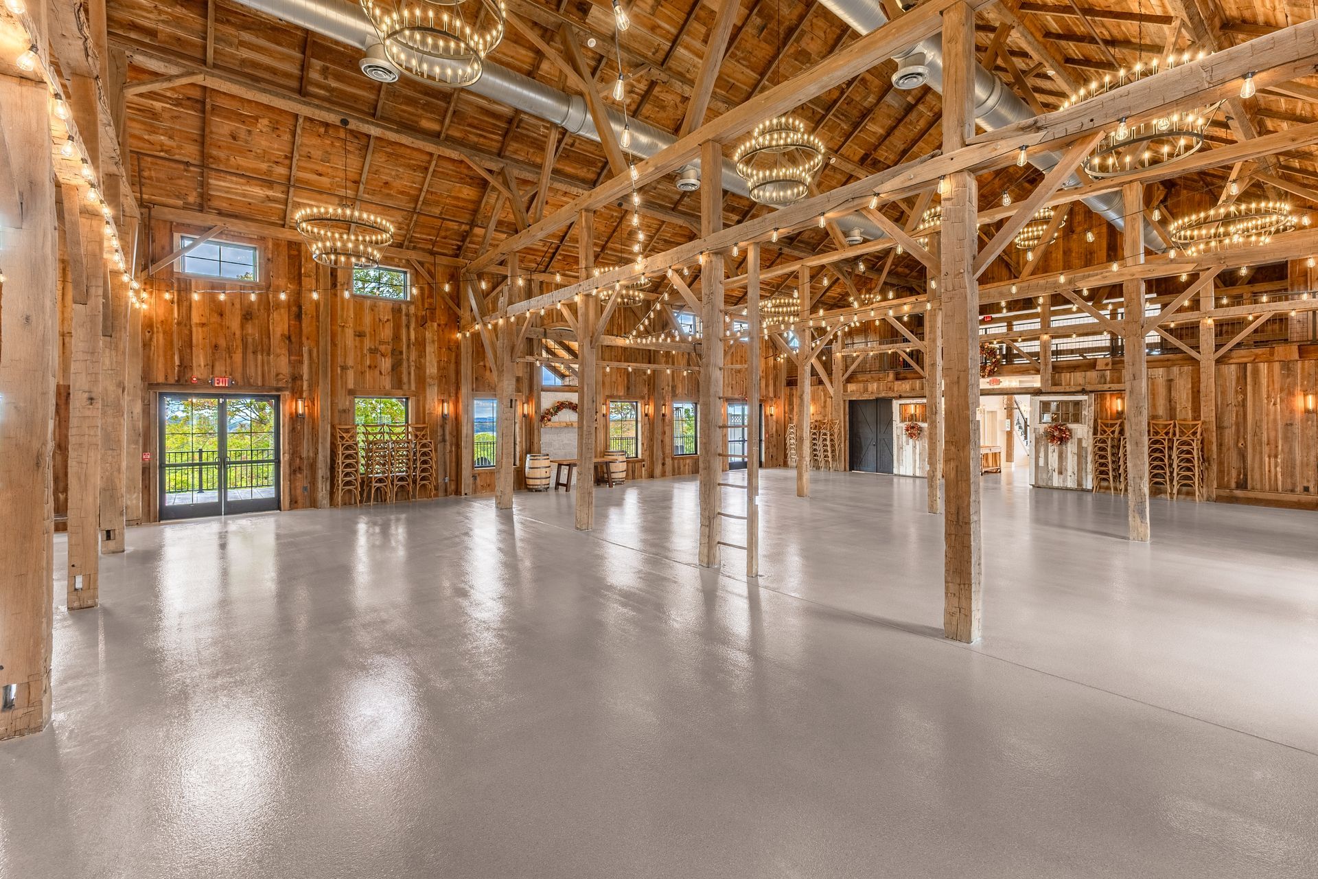 Spacious unfinished wooden building interior with exposed beams and a polished concrete floor