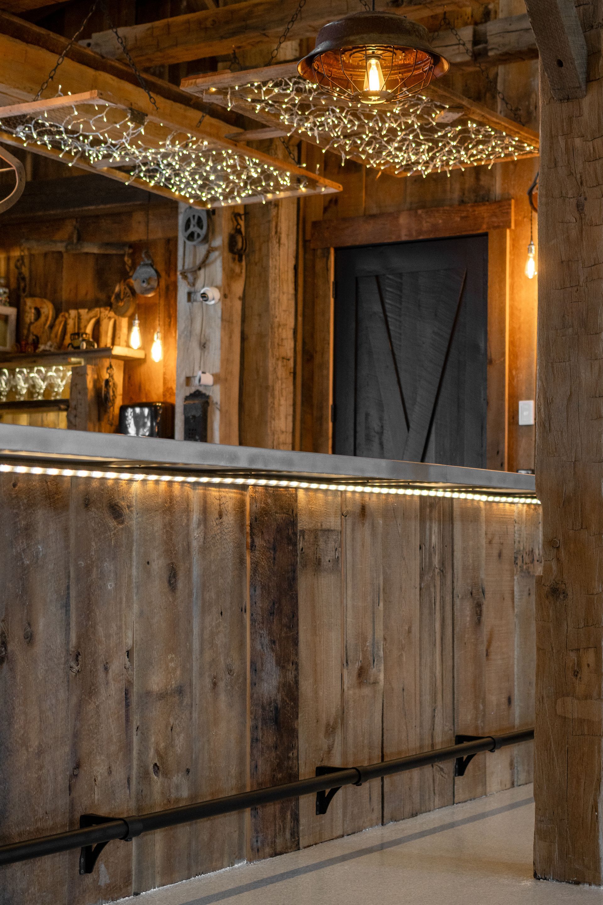 Rustic wooden bar interior with string lights and a large wooden counter