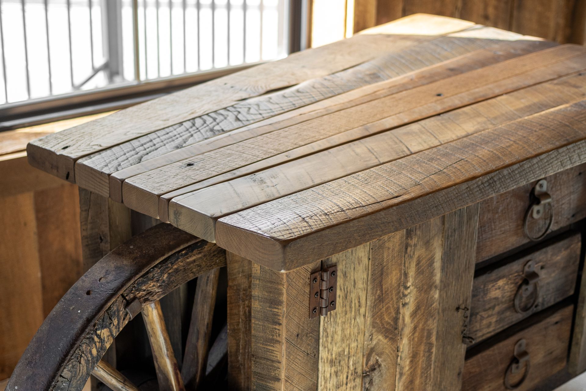 Rustic wooden workbench with a metal vise near a window