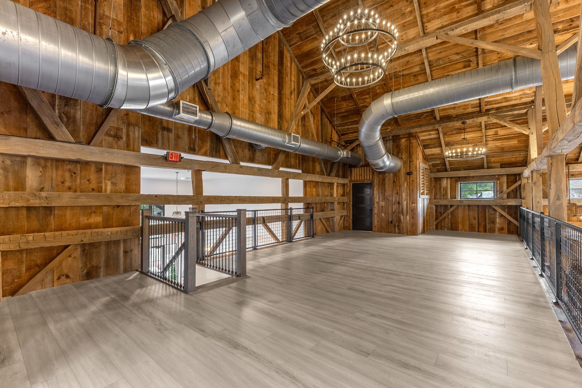 Spacious unfinished industrial loft with exposed ducts, wood framing, and polished concrete floor