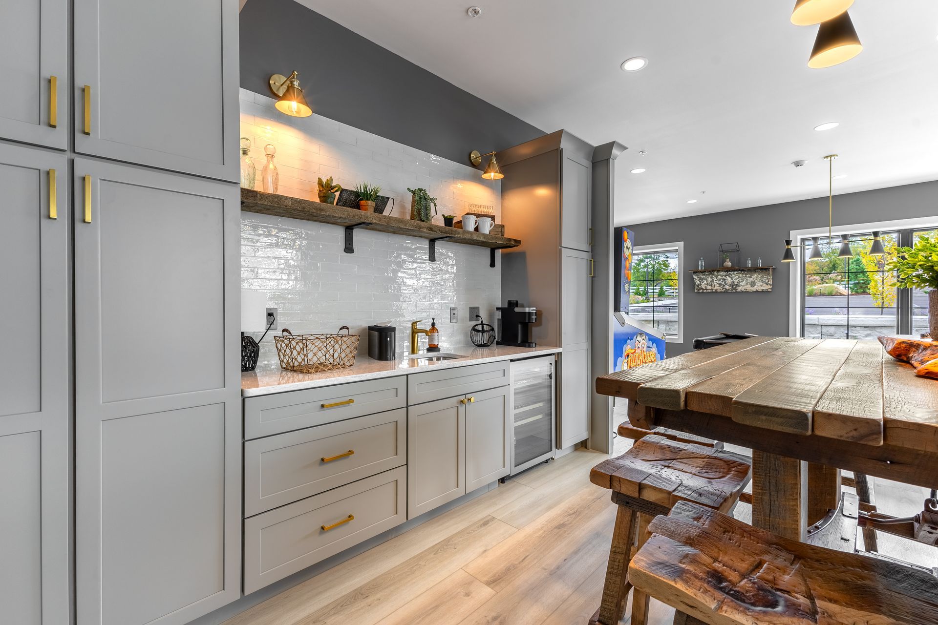 Modern kitchen with gray cabinets, marble island, pendant lights, and wooden stools