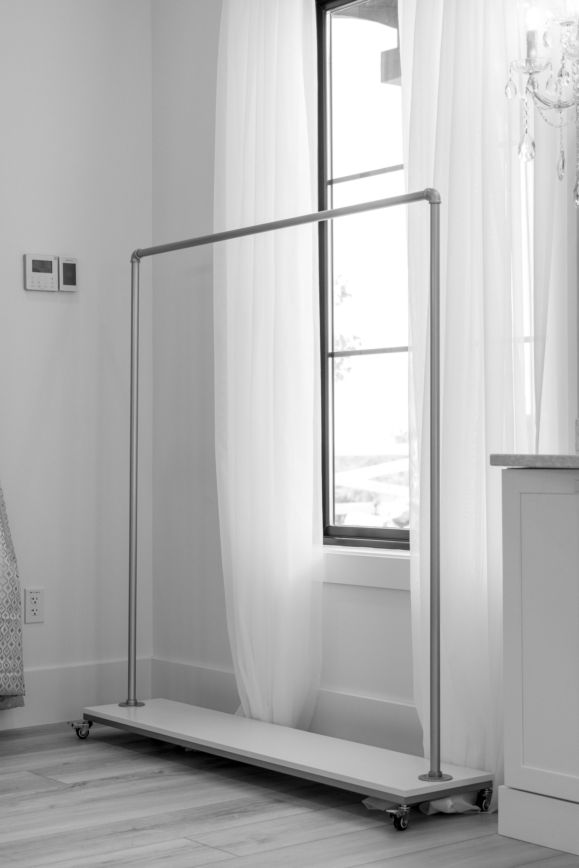 Portable garment rack by a window in a bright room