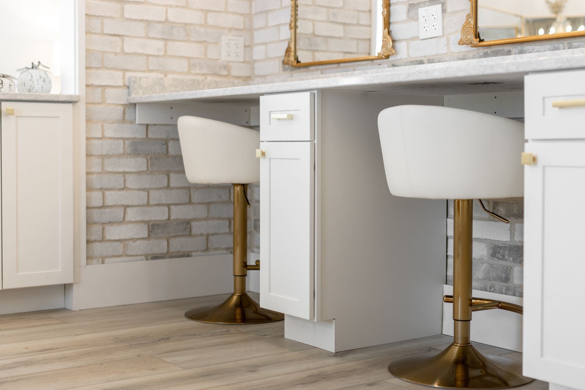 Bright white vanity desk with two white stools against a white brick wall in a modern room