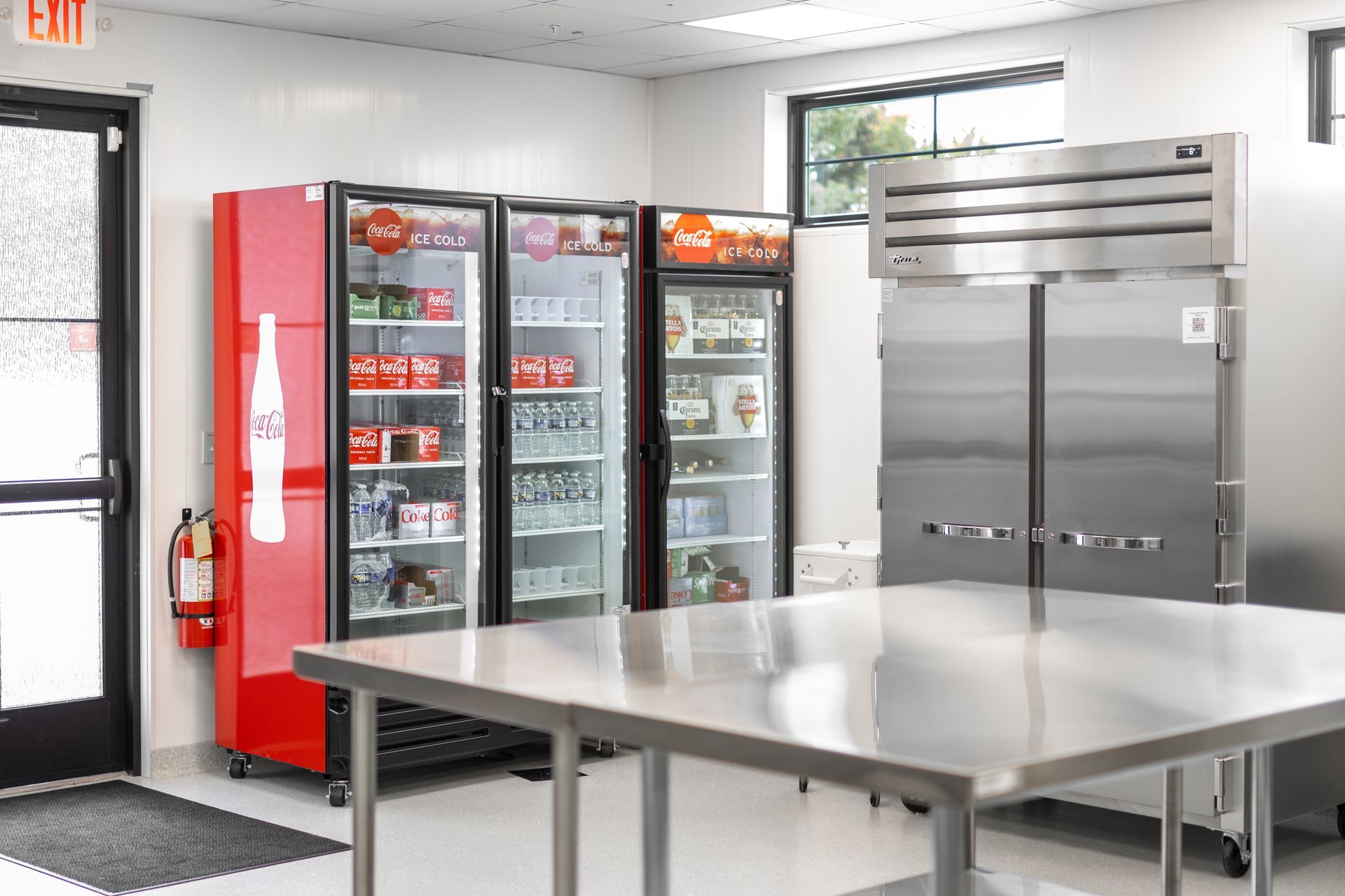 Kitchen with vending machines, stainless tables, and a large serving counter