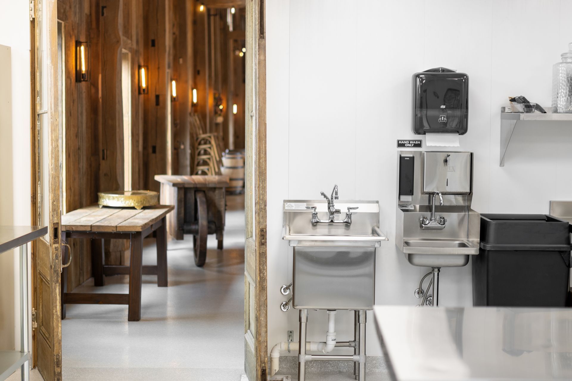 White Oak 1838 interior with wooden tables, warm pendant lights, and stainless steel sinks and coffee equipment
