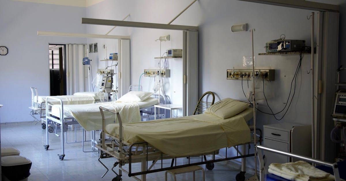 A hospital room with a lot of beds and a projector on the wall.