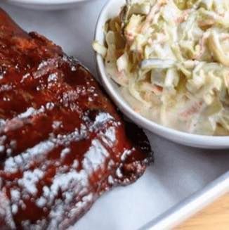 Barbecue ribs with coleslaw served on a tray in a cafeteria-style meal