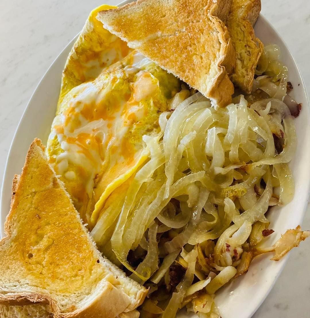 Open-faced melted cheese sandwich with toasted bread and shredded potatoes on a white plate