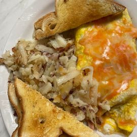 Plate with toast, shredded hash browns, and a cheesy egg omelet on a white dish.