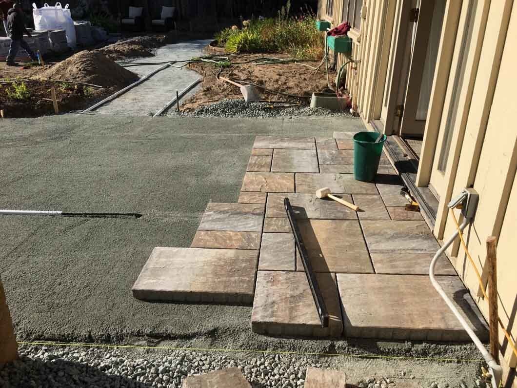 A concrete walkway is being built in front of a house.