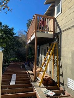 A wooden deck is being built on the side of a house.