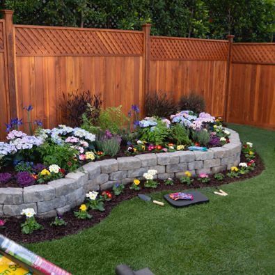 A garden with flowers and a wooden fence