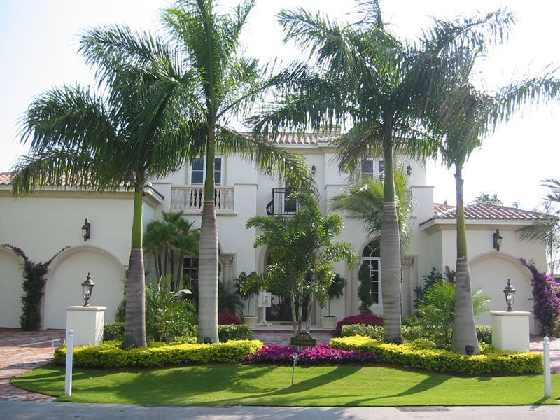 A large white house with palm trees in front of it