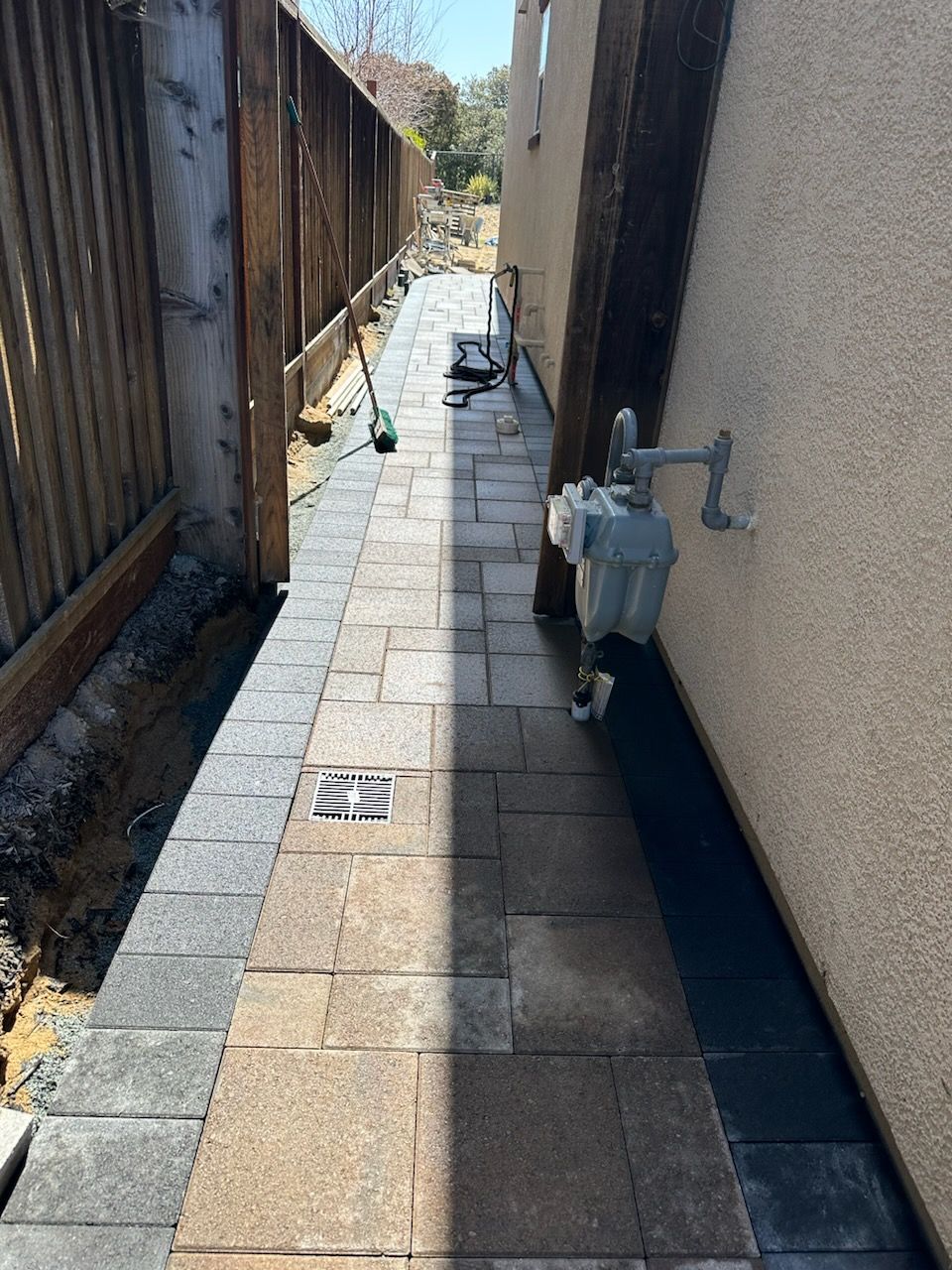 A sidewalk is being built in the backyard of a house.