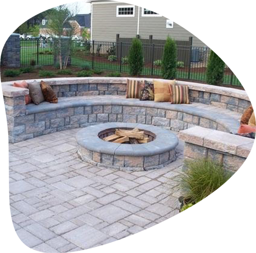 outdoor concrete bench with pillows and fireplace