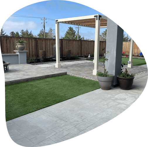 concrete pavers with green landscape inside fenced yard
