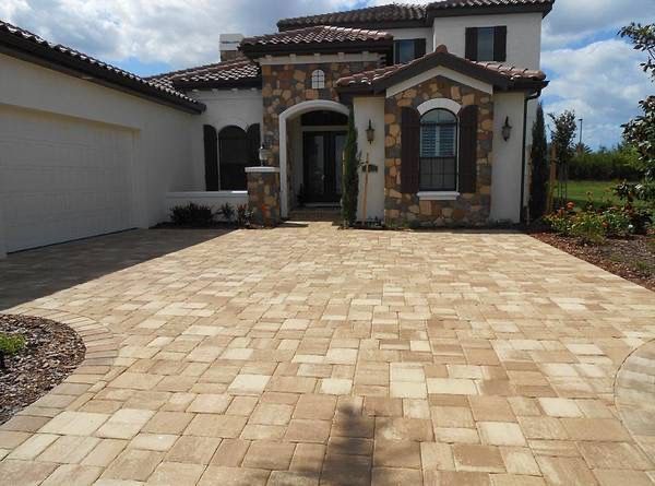 A large house with a brick driveway in front of it