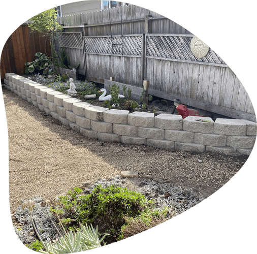 landscape retaining walls in a wood-fenced backyard