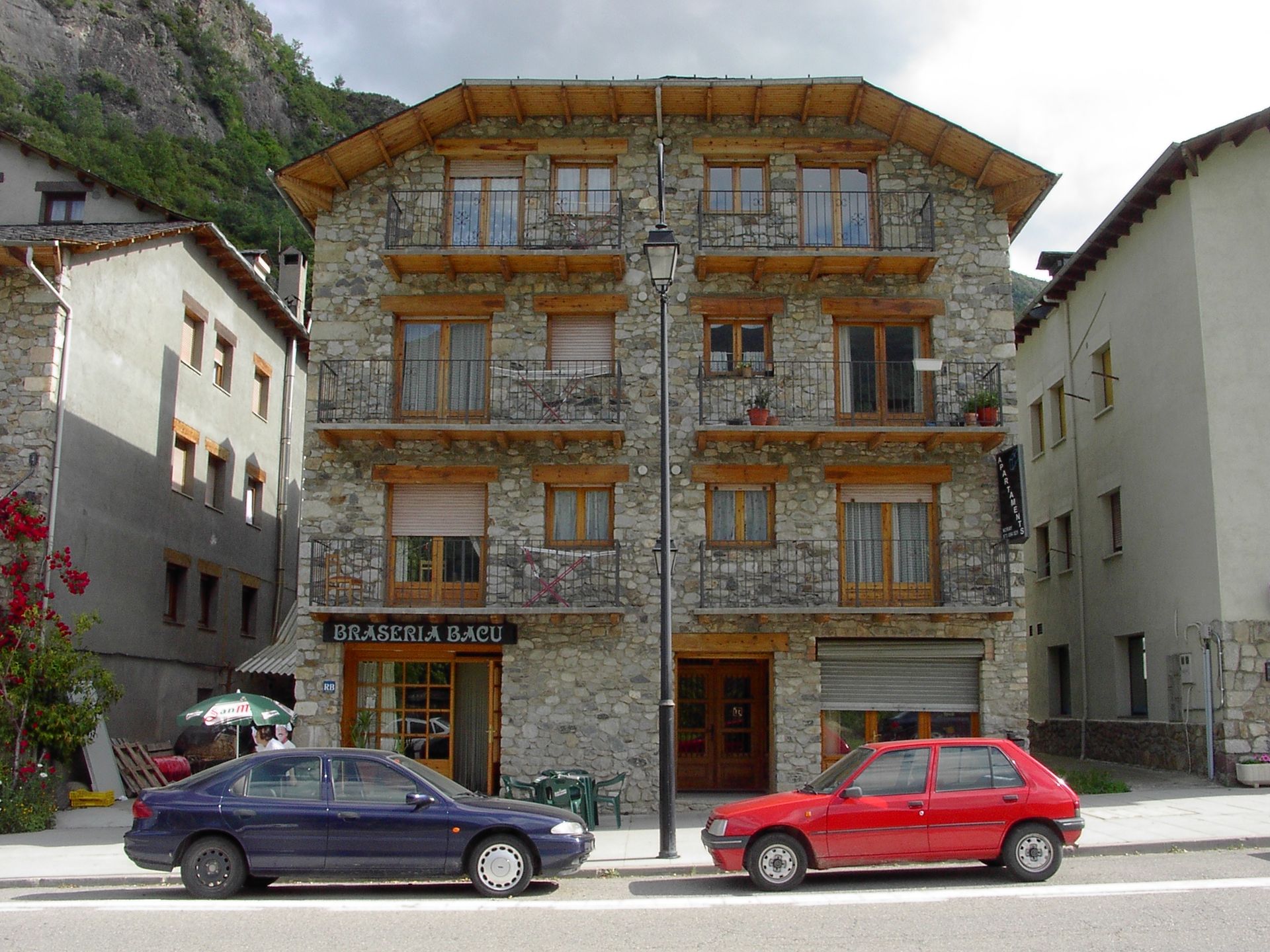 Façana de pedra dels Apartaments Noray, amb balcons de fusta.