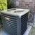 Goodman air conditioning unit outside a brick building.