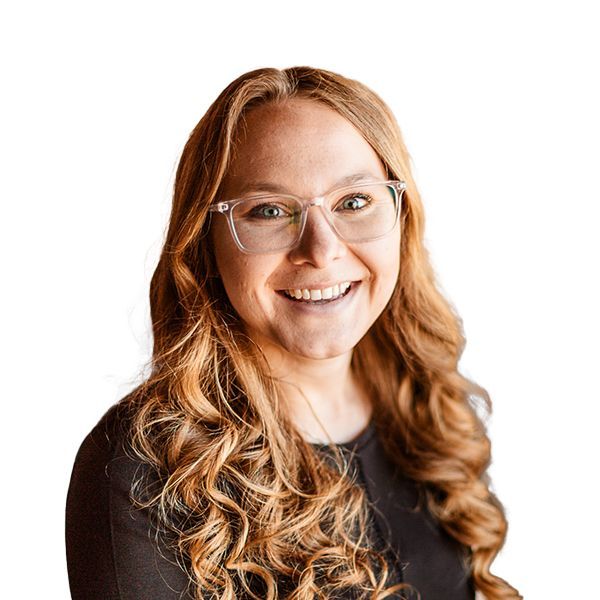 A woman wearing glasses and a black shirt is smiling.