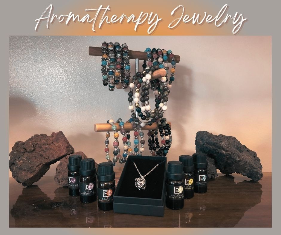 Aromatherapy jewelry display with beaded bracelets, essential oil bottles, crystals, and a necklace on a stand.