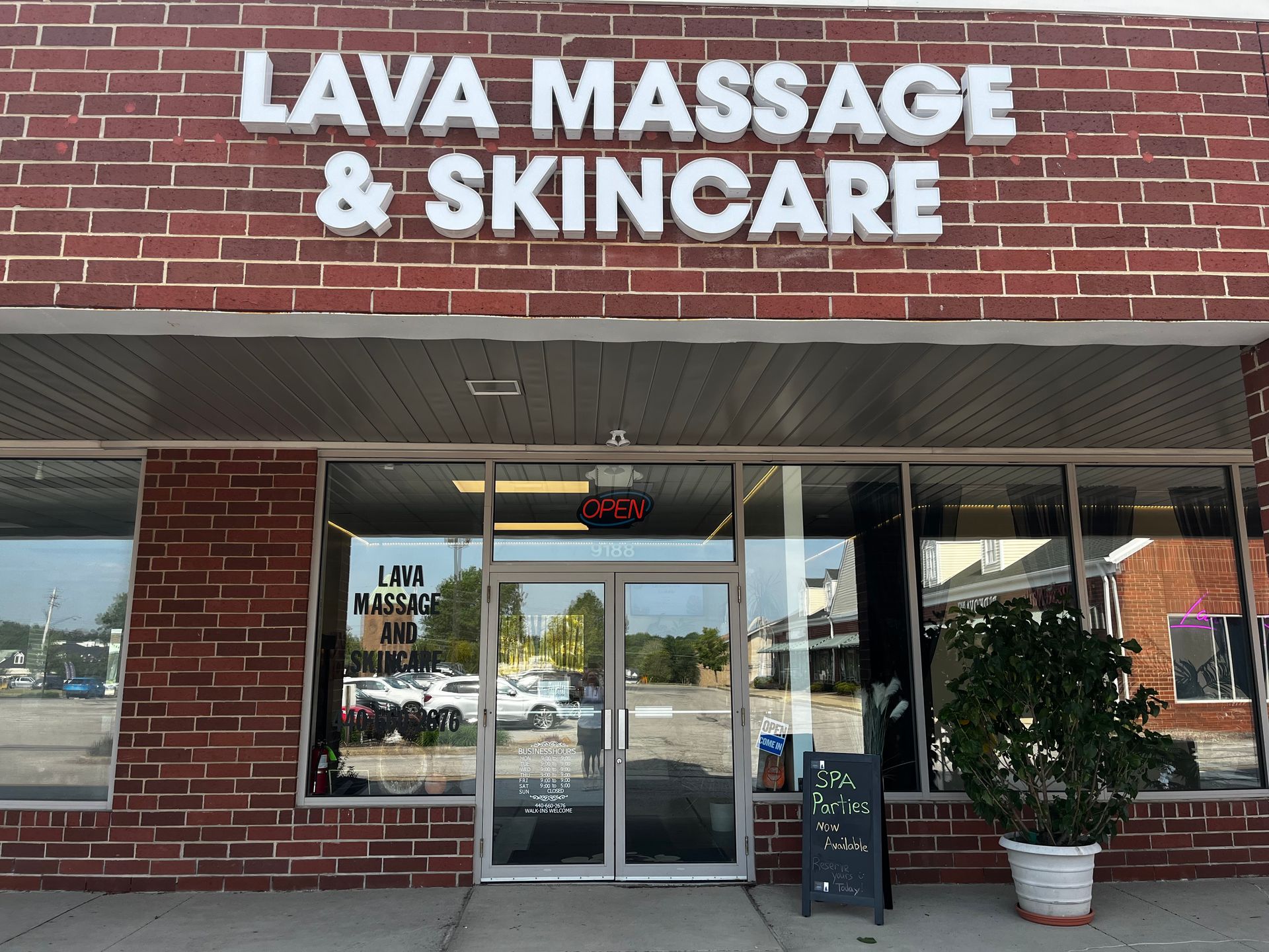 Storefront sign reading “LAVA MASSAGE & SKINCARE” above a brick-front spa entrance