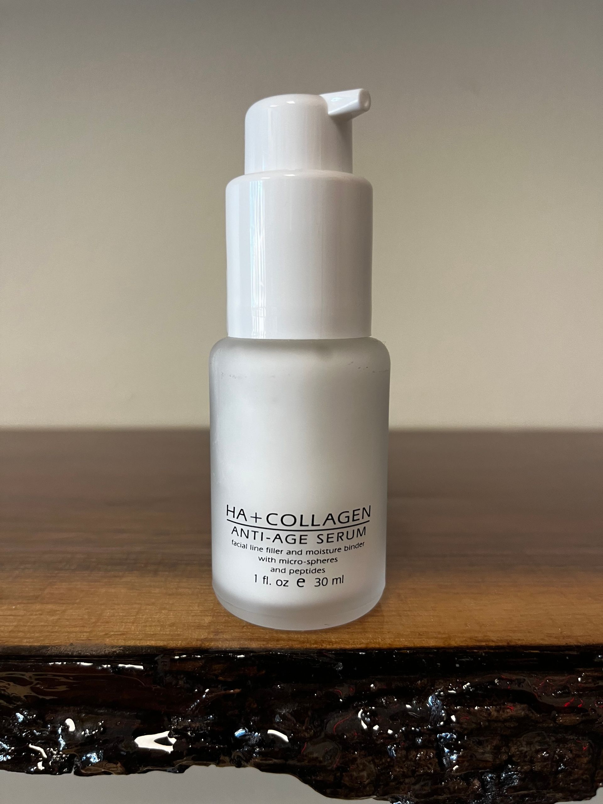 White pump bottle on a wooden surface against a beige wall.