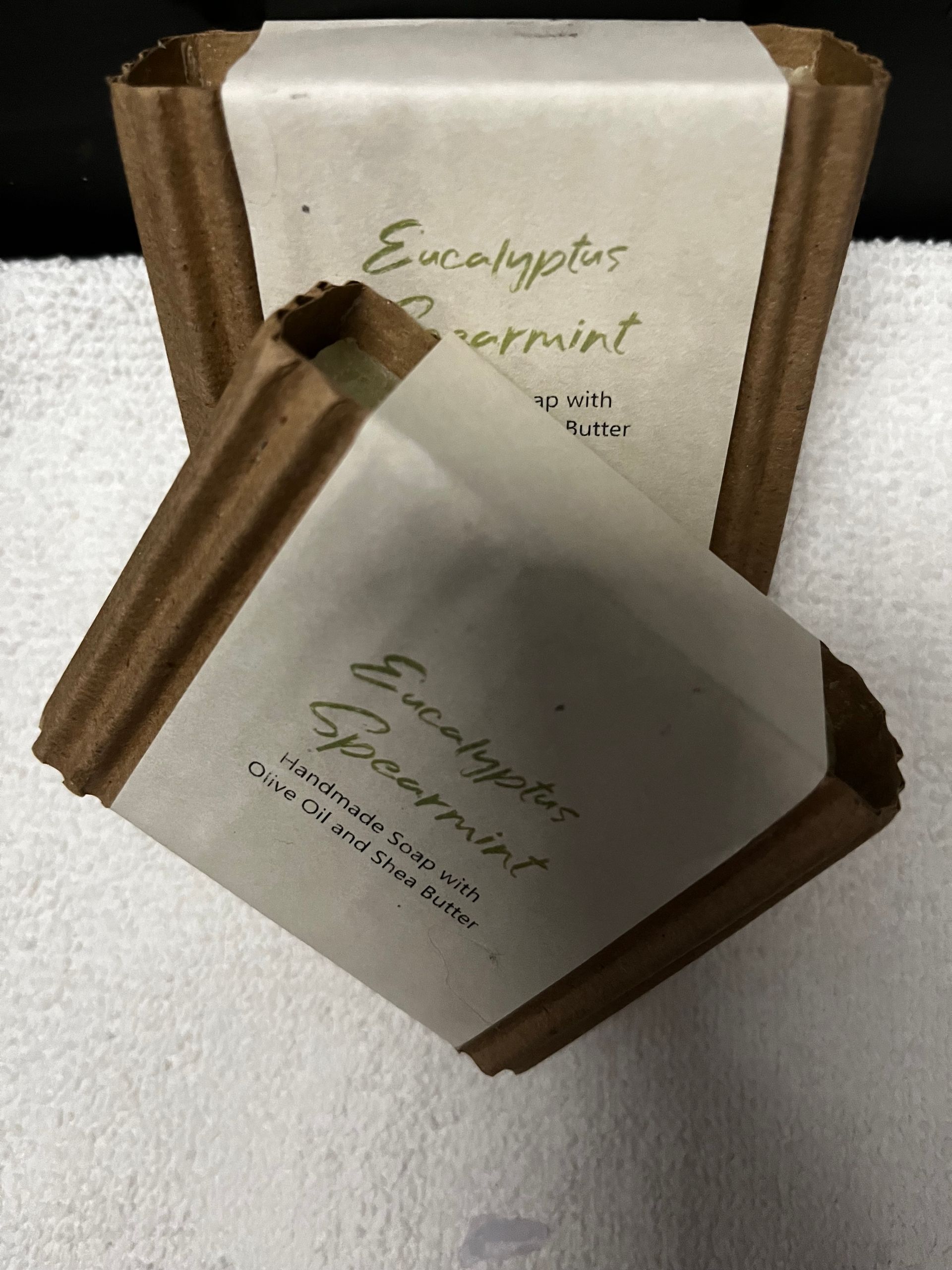Two brown-and-white sachets labeled “Eucalyptus” and “Jasmine” on a white surface