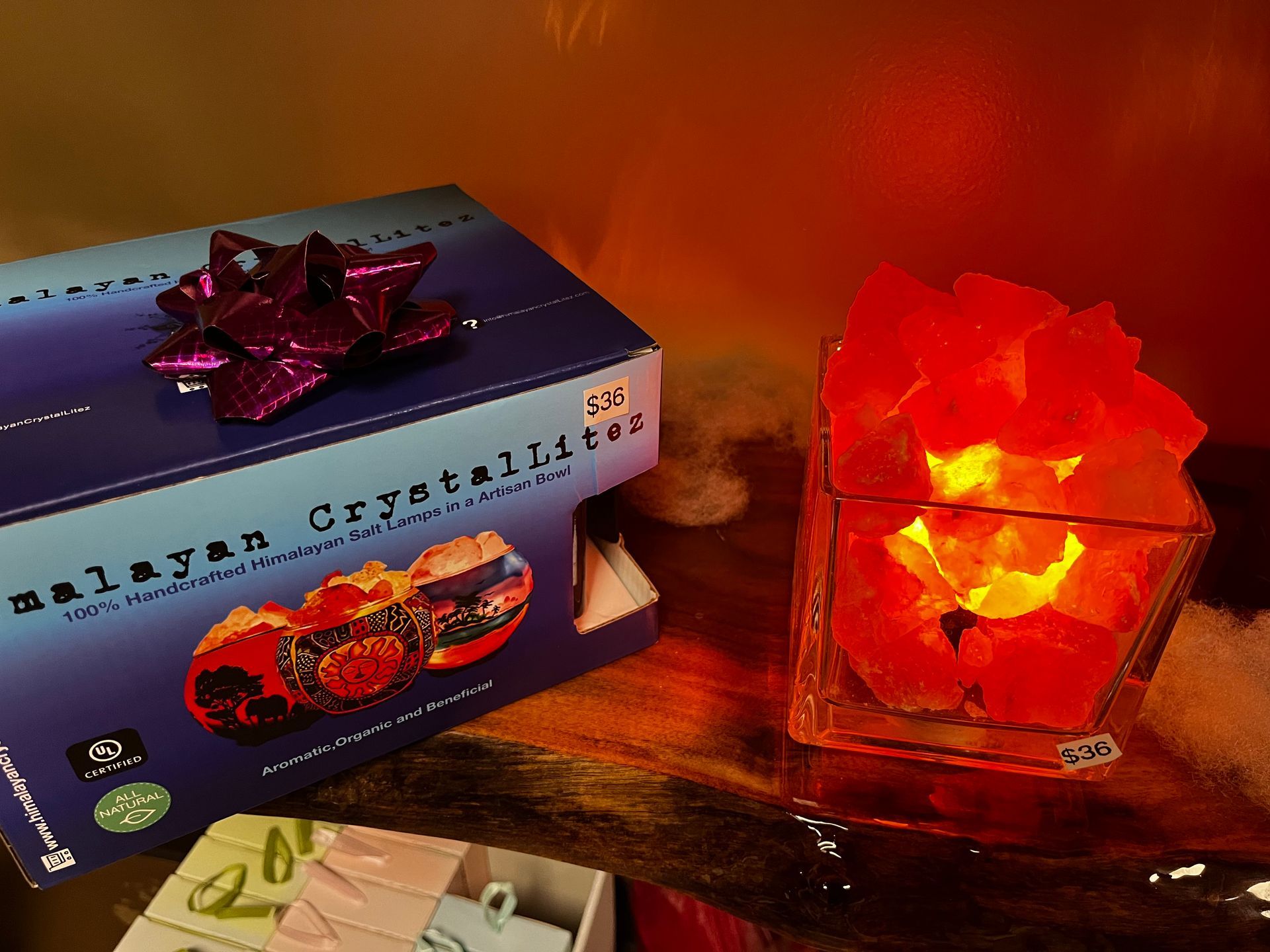 Blue boxed gift and glowing red crystal lamp on a wooden table.