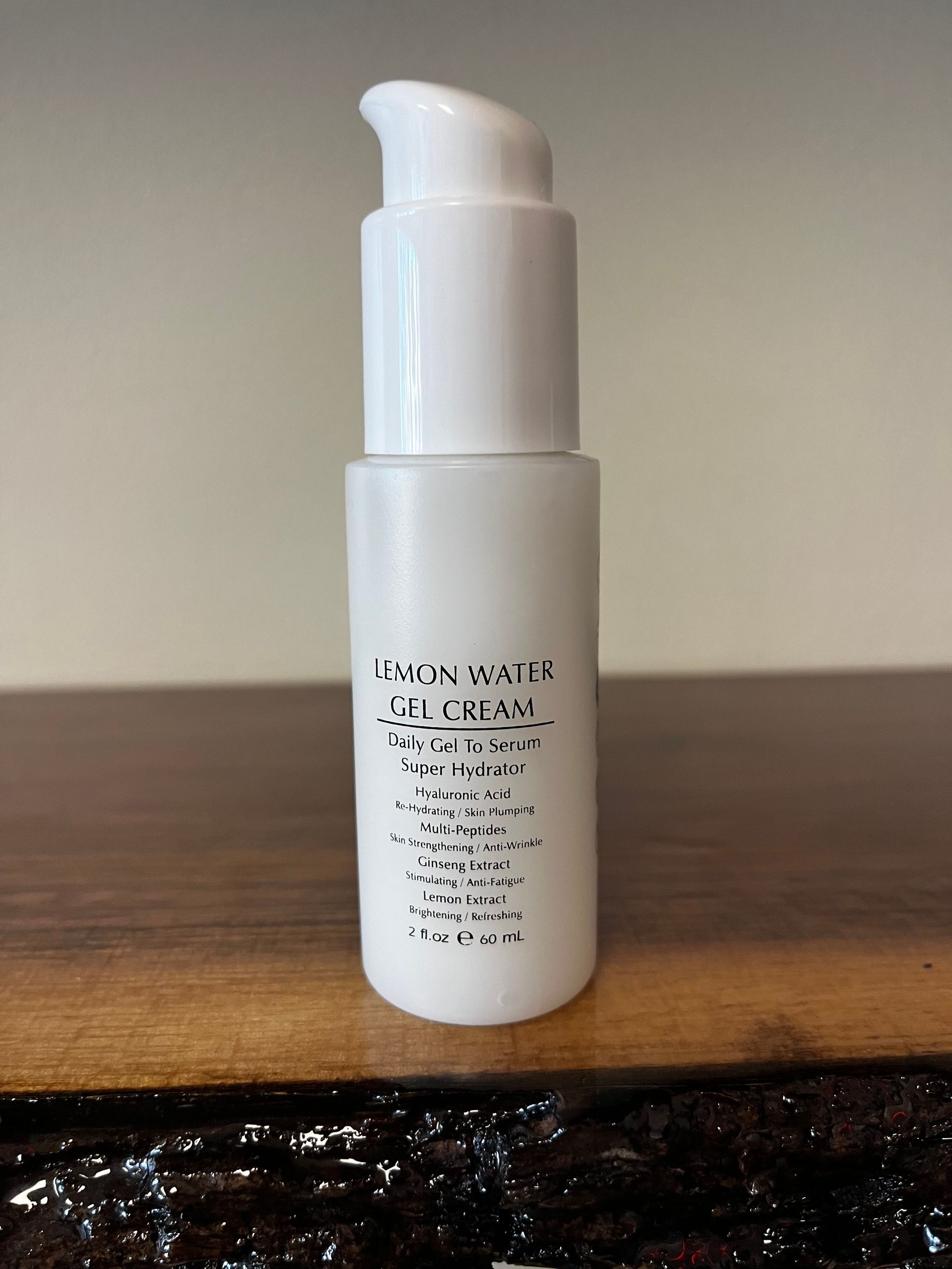 White pump bottle on a wooden surface against a plain wall.
