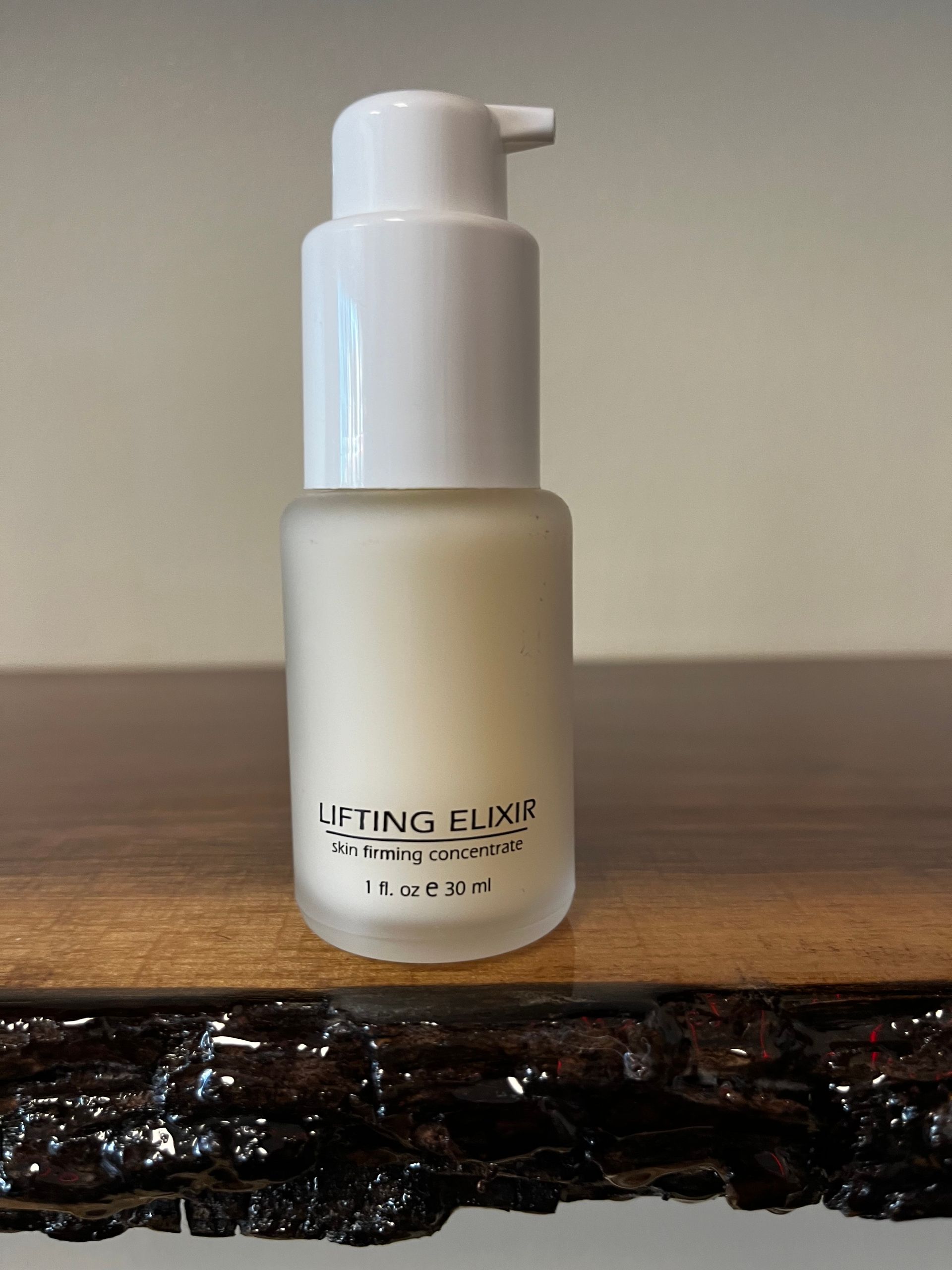 White pump bottle on a wooden surface against a plain wall.
