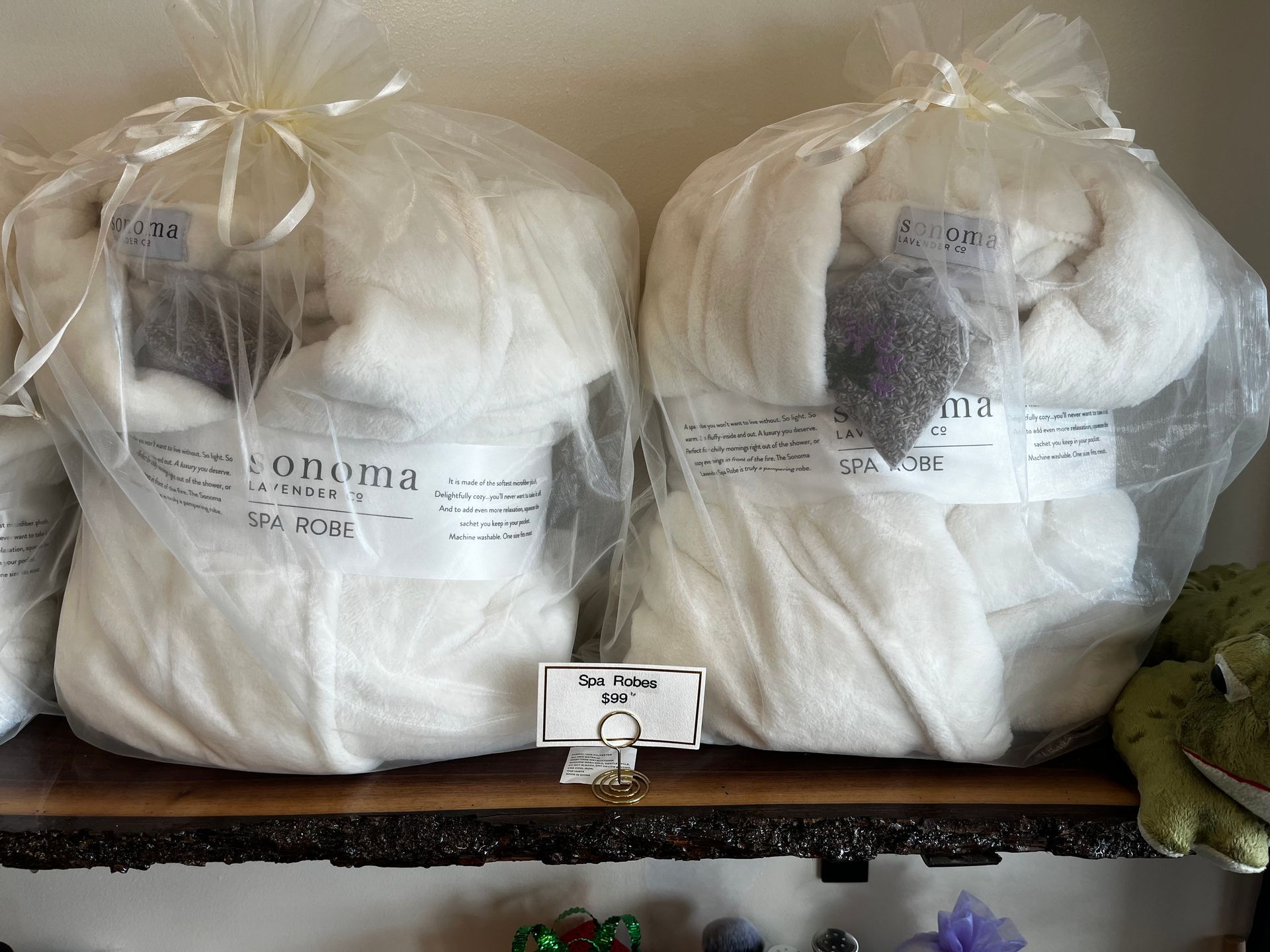 Two large clear bags of white yarn or wool on a shelf, with a small label in front.