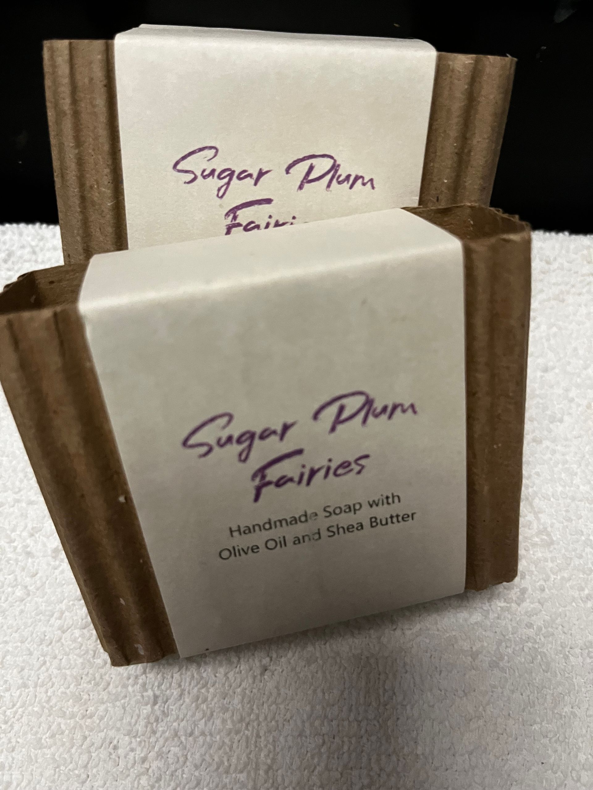 Two white Sugar Plum Fairs cards in brown holders on a gray surface