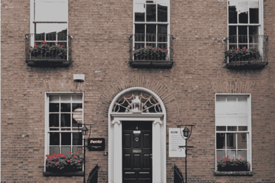 Red brick house with arch over black door
