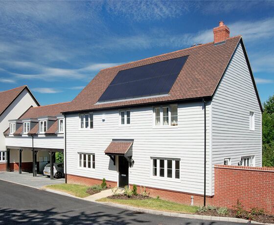 A white house with solar panels on the roof