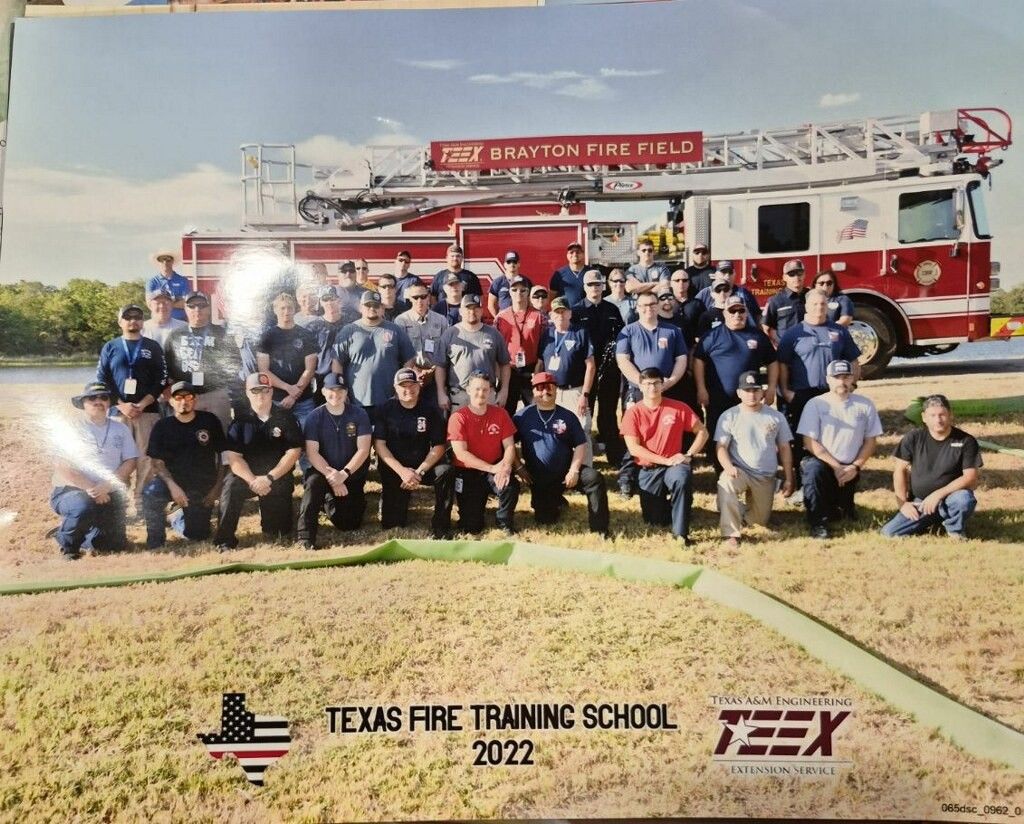Group photo of Texas Fire Training School 2022 participants posing in front of a red fire truck.