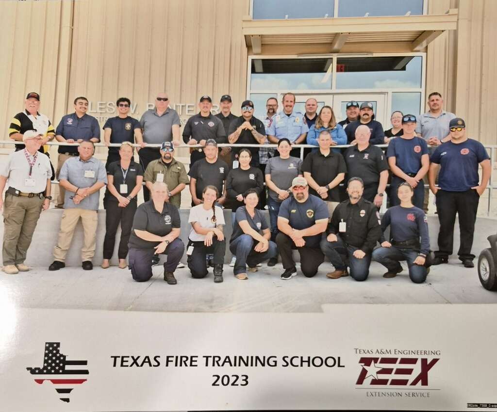 Group photo of Texas Fire Training School 2023 participants standing outside a building with TFS logos.